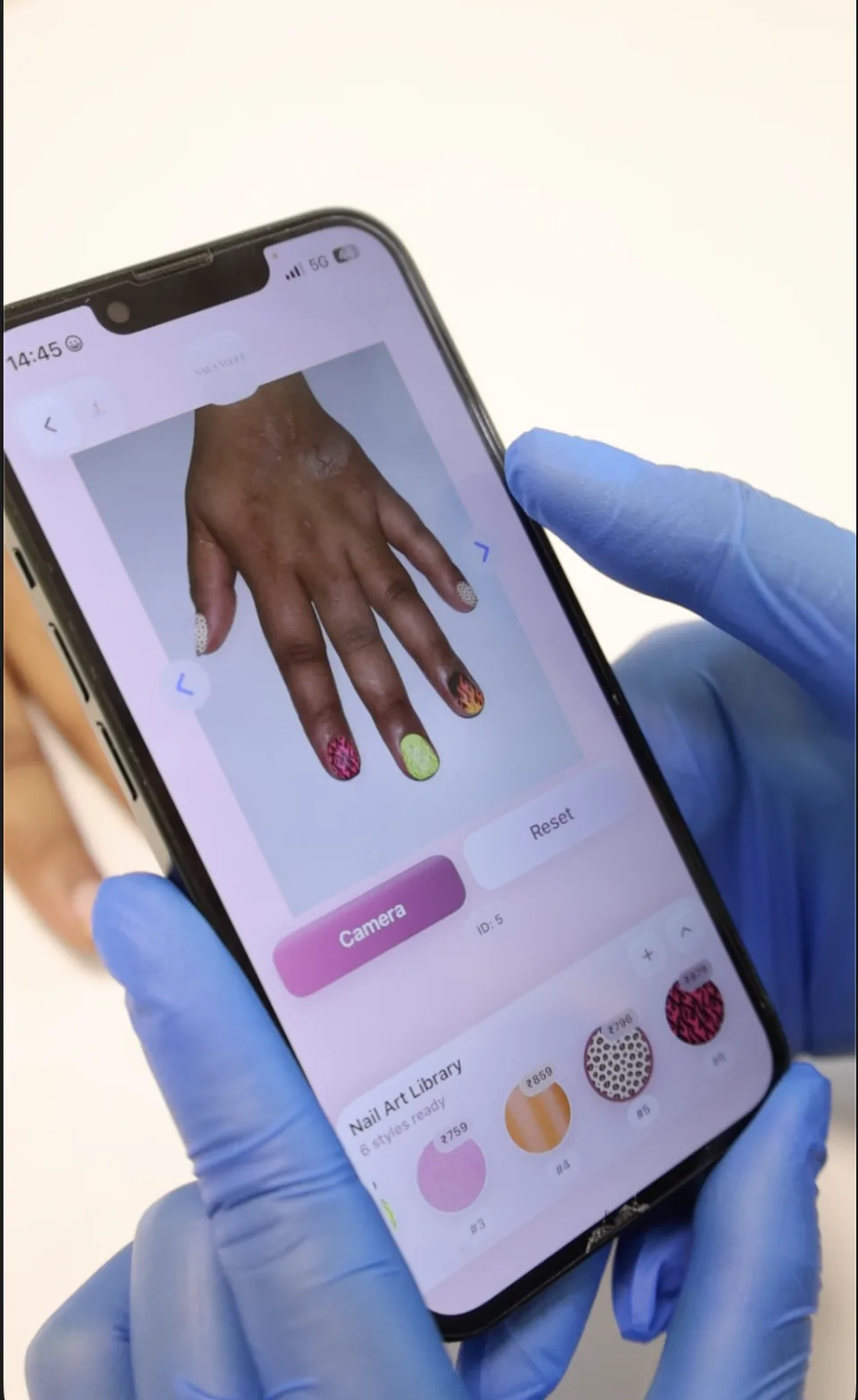 Different virtual nail art designs are visible on the client’s hand, above the salon’s nail art library.